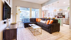 Een moderne woonkamer met een modulaire bank, een salontafel en een flatscreen televisie.