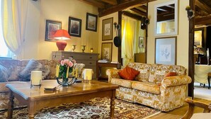 A cozy living room with a wooden coffee table, a patterned sofa, and a floral arrangement.