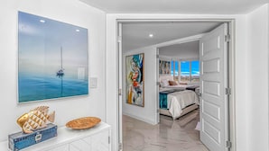 Een moderne slaapkamer met een bed, een groot raam en kunstwerken aan de muren.