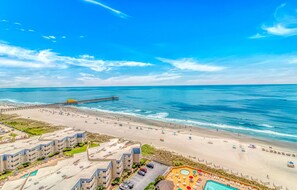 A beachfront hotel with multiple buildings, a pier extending into the ocean, and a swimming pool area. - One-of-a-Kind Oceanfront, Designer Furnished, Luxury Condo w/ Resort Amenities (Myrtle Beach)