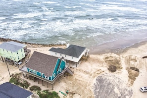 Exterior - Martinis & Bikinis, a beach front house with toes in the sand drink in the hand. (Freeport)