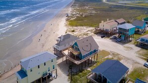 A coastal property with beachfront houses, a sandy beach, and a clear view of the ocean. - Martinis & Bikinis, a beach front house with toes in the sand drink in the hand. (Freeport)