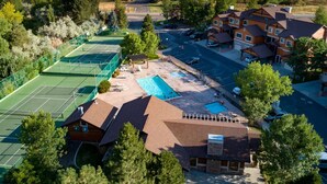 Área residencial com quadra de tênis, piscina e casas.