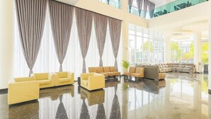 A spacious lobby with a seating area, large windows, and a high ceiling. - THE Reed Hotel Melaka Formerly E-red Hotel Melaka (Malacca City)