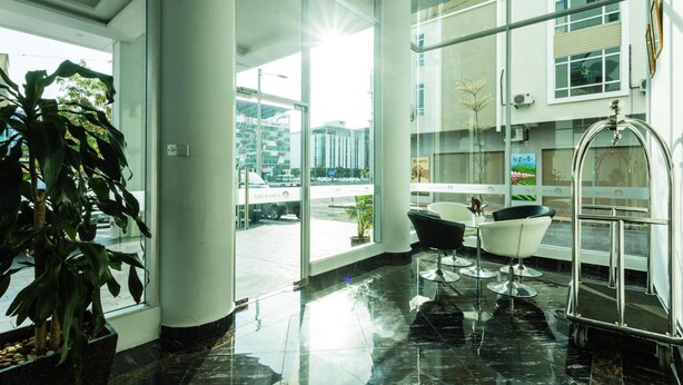 A modern hotel lobby with large windows, a reception desk, and a seating area. - THE Reed Hotel Melaka Formerly E-red Hotel Melaka (Malacca City)