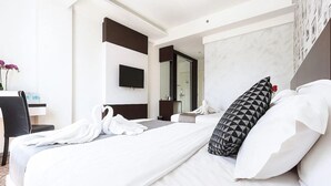 A hotel room with a large bed, a desk with a chair, a TV mounted on the wall, and a bathroom visible through an open door. - THE Reed Hotel Melaka Formerly E-red Hotel Melaka (Malacca City)