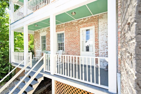 A two-story brick building with a balcony and a staircase. - Hudson Mariner (Hudson)