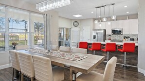 Una cocina moderna con armarios blancos, un refrigerador de acero inoxidable y un microondas.