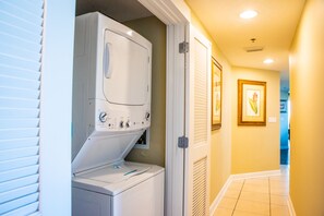 Convenient laundry area with a front-loading washing machine and space.