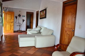 Relax in a spacious living area with a large L-shaped sofa and additional seating options.