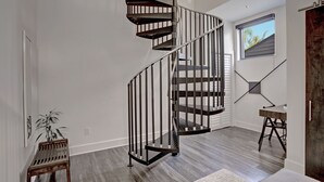 Ein modernes Interieur mit einer Wendeltreppe, einem Essbereich und einem Fenster mit Ausblick.