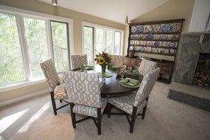 Enjoy meals in this inviting dining area with a round table and six chairs, set with placemats, plates, and glassware.
