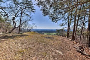 A forested hiking trail with a view of distant fields and mountains. - Secluded Ridgetop Hideaway w/ Valley Views! (Menlo)