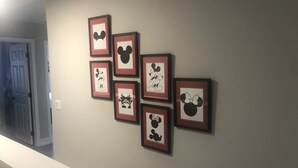 En hall med en vit bänk och inramade tavlor på väggen.
