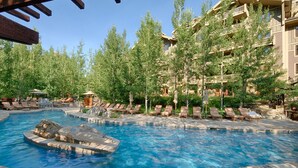 A pool area with multiple lounge chairs and a small boat. - 6/20 to 6/27 or 11/22 to 11/29, Four Seasons 3 BDRM, 3 Full Bath, Jackson Hole (Teton Village)