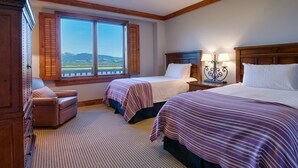 A hotel room with two beds, a wooden headboard, a window with a view of the mountains, and a checkered floor. - 6/20 to 6/27 or 11/22 to 11/29, Four Seasons 3 BDRM, 3 Full Bath, Jackson Hole (Teton Village)