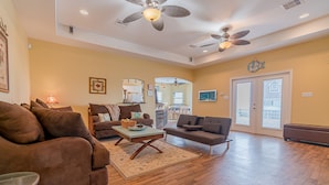 A spacious living room with two sofas, a coffee table, and a ceiling fan. - Stunning beach views-100 steps to beach-Huge deck (Surfside Beach)