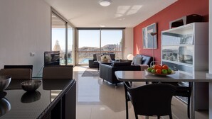 A modern living room with a dining area, large windows, and a view of the cityscape. - Spectacular villa with private pool, sea views, barbecue and relaxing environment (San Bartolomé de Tirajana)