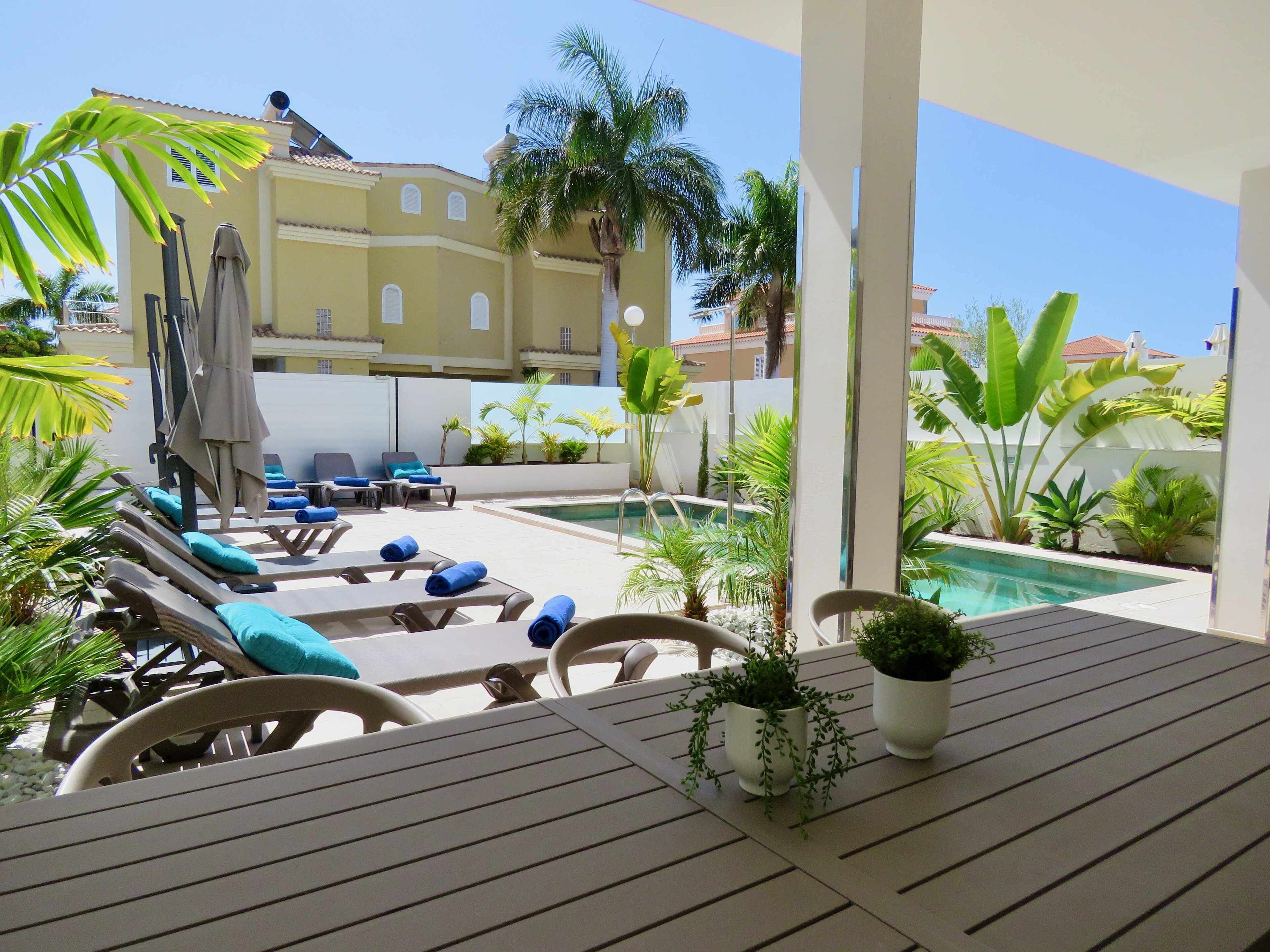 Un espace extérieur abrité, doté de chaises longues et d’une piscine.