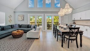 A spacious living room with a high ceiling, a dining area, and a kitchen. - P77 - Sombrero Beach - Pool home offering 3 bedrooms, private pool and deep water dockage! (Mararathon)