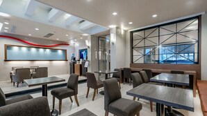 A modern restaurant with multiple tables and chairs, a large window with a geometric design, and a ceiling with skylights. - Guide Hotel - Kaohsiung Shinkuchan (Kaohsiung)
