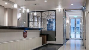 A hotel reception area with a modern design, including a reception desk, a glass partition, and a clean, tiled floor. - Guide Hotel - Kaohsiung Shinkuchan (Kaohsiung)