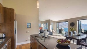 Una cocina moderna con una isla grande, un comedor con vistas y una sala de estar con chimenea.