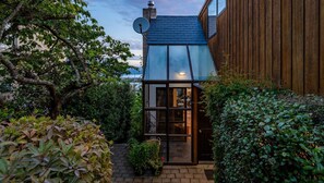 Contemporary building with a sloped roof and lush green surroundings.