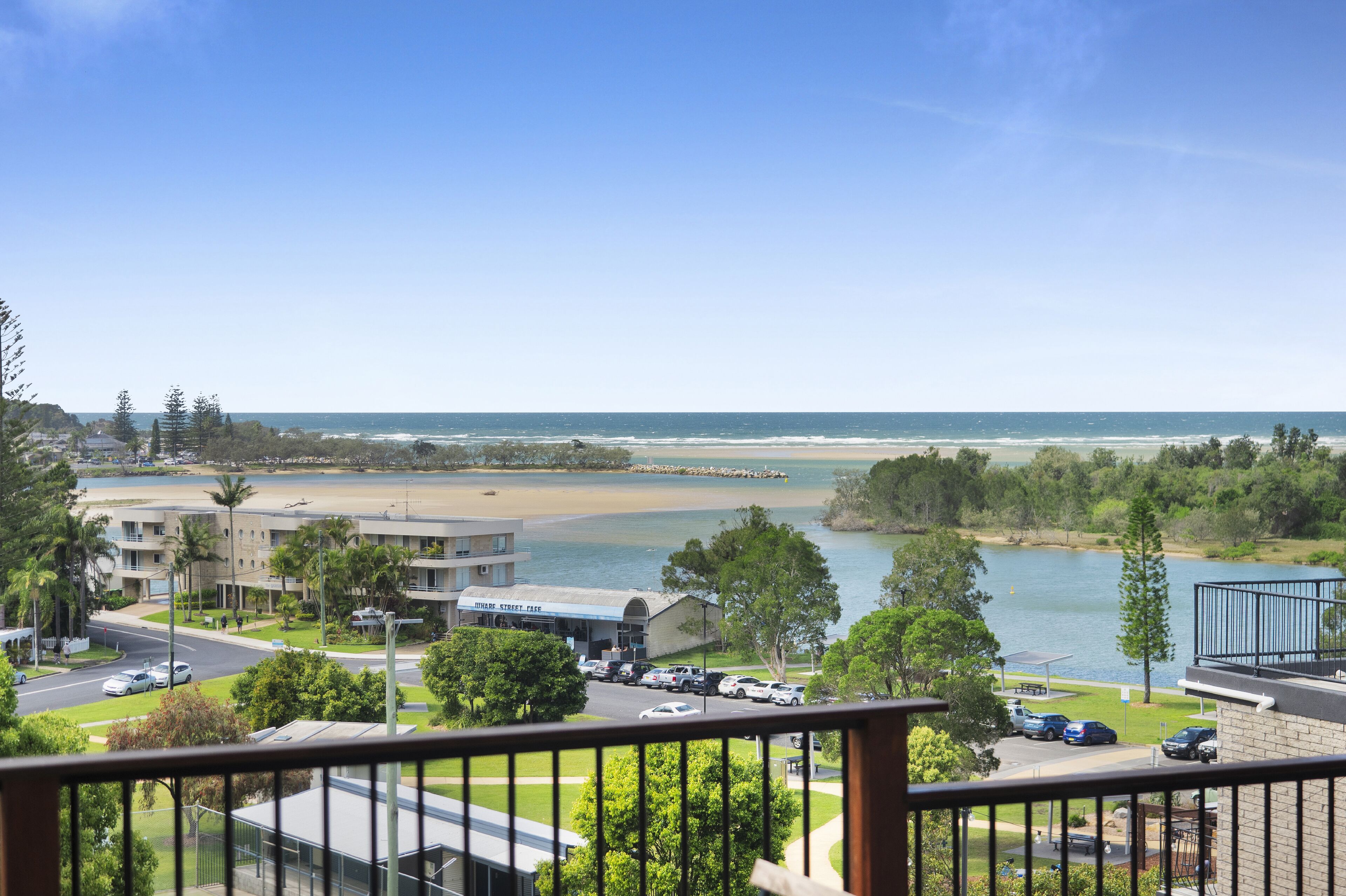 Vista costera con playa, aparcamiento y un edificio con la leyenda 'Oceanview Street Cafe'.