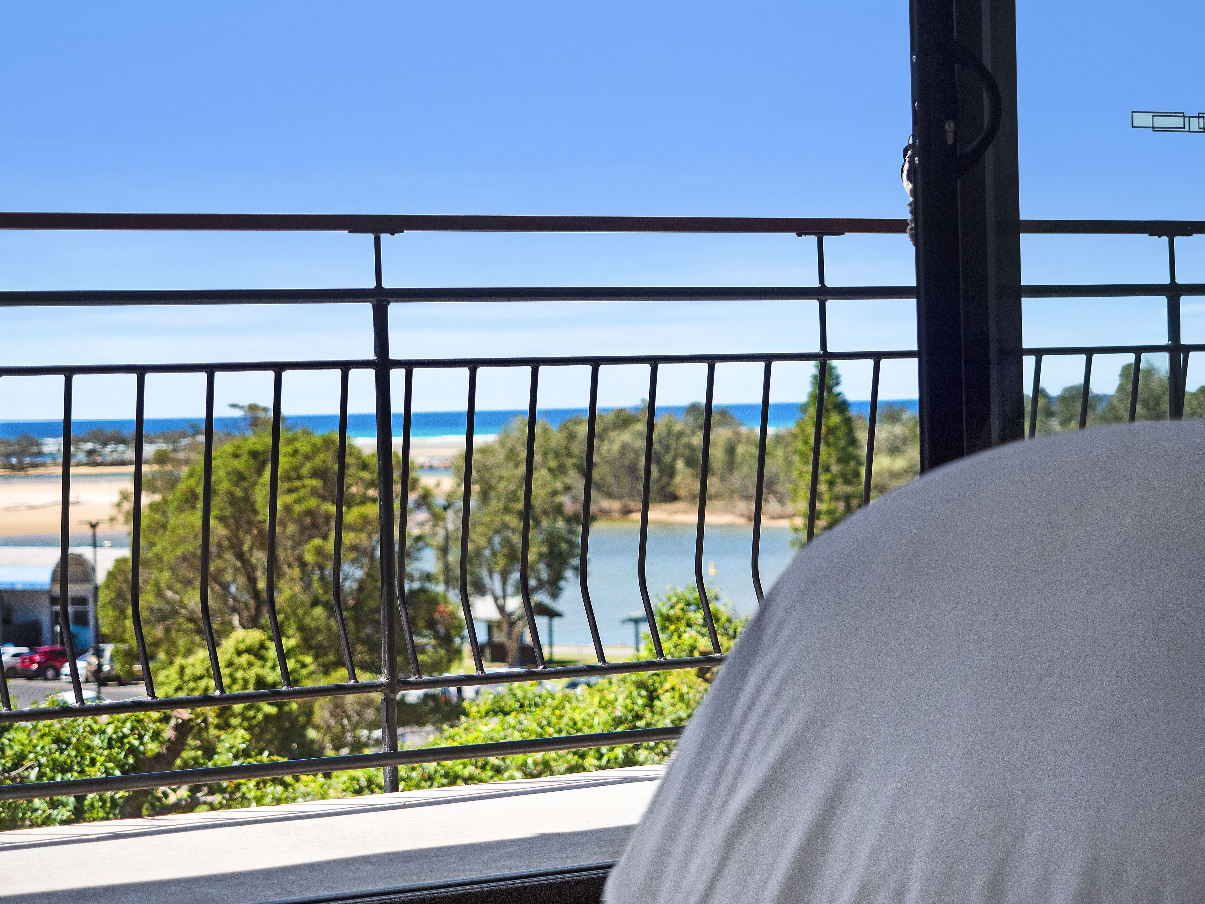 A balcony with a view of a beach and ocean.