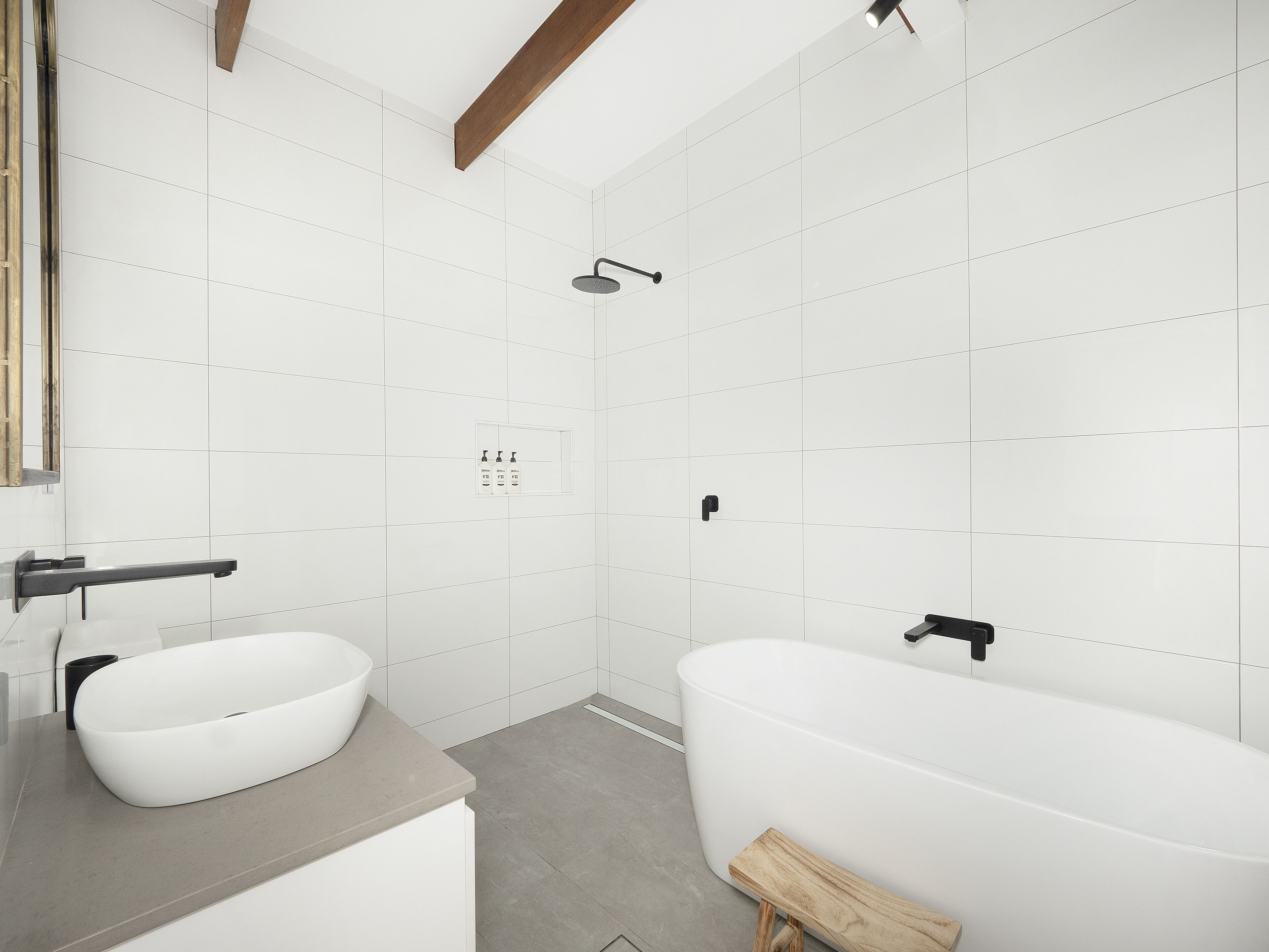 A modern bathroom with a freestanding bathtub, a vessel sink, and a showerhead.