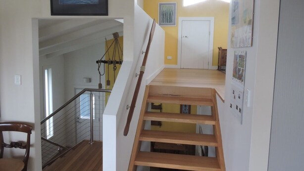 A staircase with wooden steps leading to a landing with a white door and a framed picture above it.