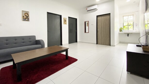 Una sala de estar moderna con un sofá gris, una mesa de centro de madera y un tapiz rojo. Hay dos puertas, un equipo de aire acondicionado y una ventana con vistas a zonas verdes.
