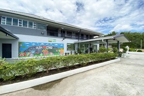 A building with a mural, a balcony, and a covered entrance area. - Hotel O Dh Residence (Kota Belud)