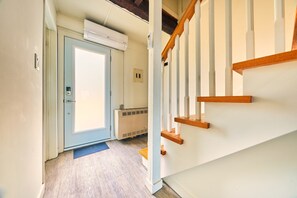 Staircase leads to a room with a door, flanked by a white handrail and steps.