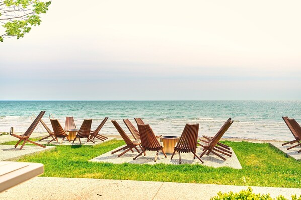 Relax in comfort with lounge chairs surrounding a central table, overlooking the calm sea.