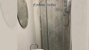 A bathroom with a glass-enclosed shower, a sink, and a mirror. - 1 Bedroom St Helens Apartment | Free WiFi | Fully Furnished (St Helens)