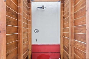 A room with a wooden interior, a white door with a lock, and a red lower section.