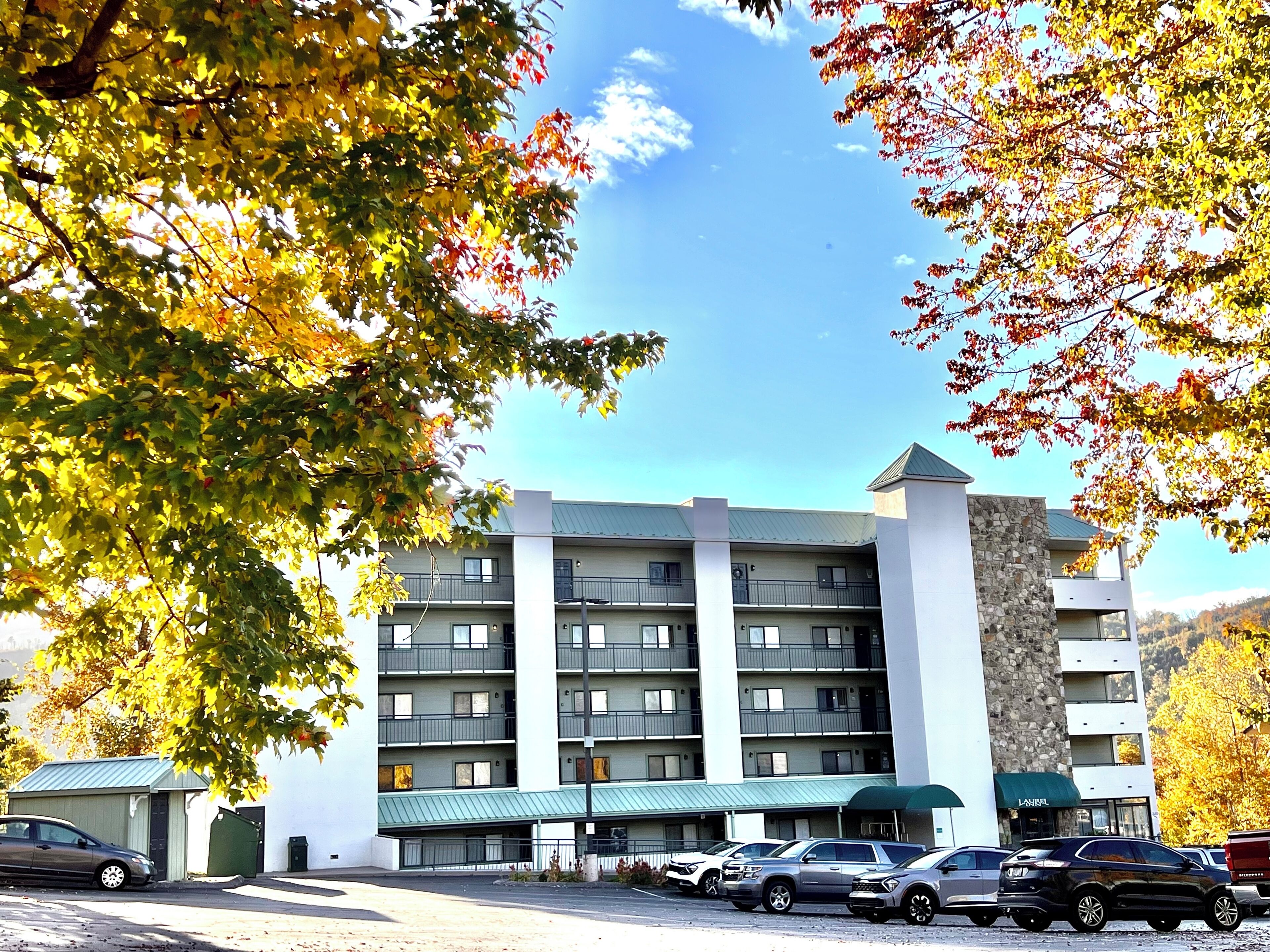 A multi-story hotel with a stone facade and a green awning.