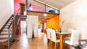 A multi-level interior with a dining area, a staircase, and a kitchen. - Holiday Home "Can Cuixa" with Pool, Wi-Fi, Air Conditioning & Garden (Santa Margarita)