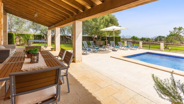 A covered outdoor area with a pool, lounge chairs, and a table with chairs. - Holiday Home "Can Cuixa" with Pool, Wi-Fi, Air Conditioning & Garden (Santa Margarita)