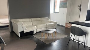Una sala de estar moderna con un sofá, una mesa redonda y una zona de bar.