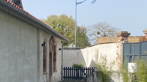Un patio con dos gallinas, una reja y una farola.