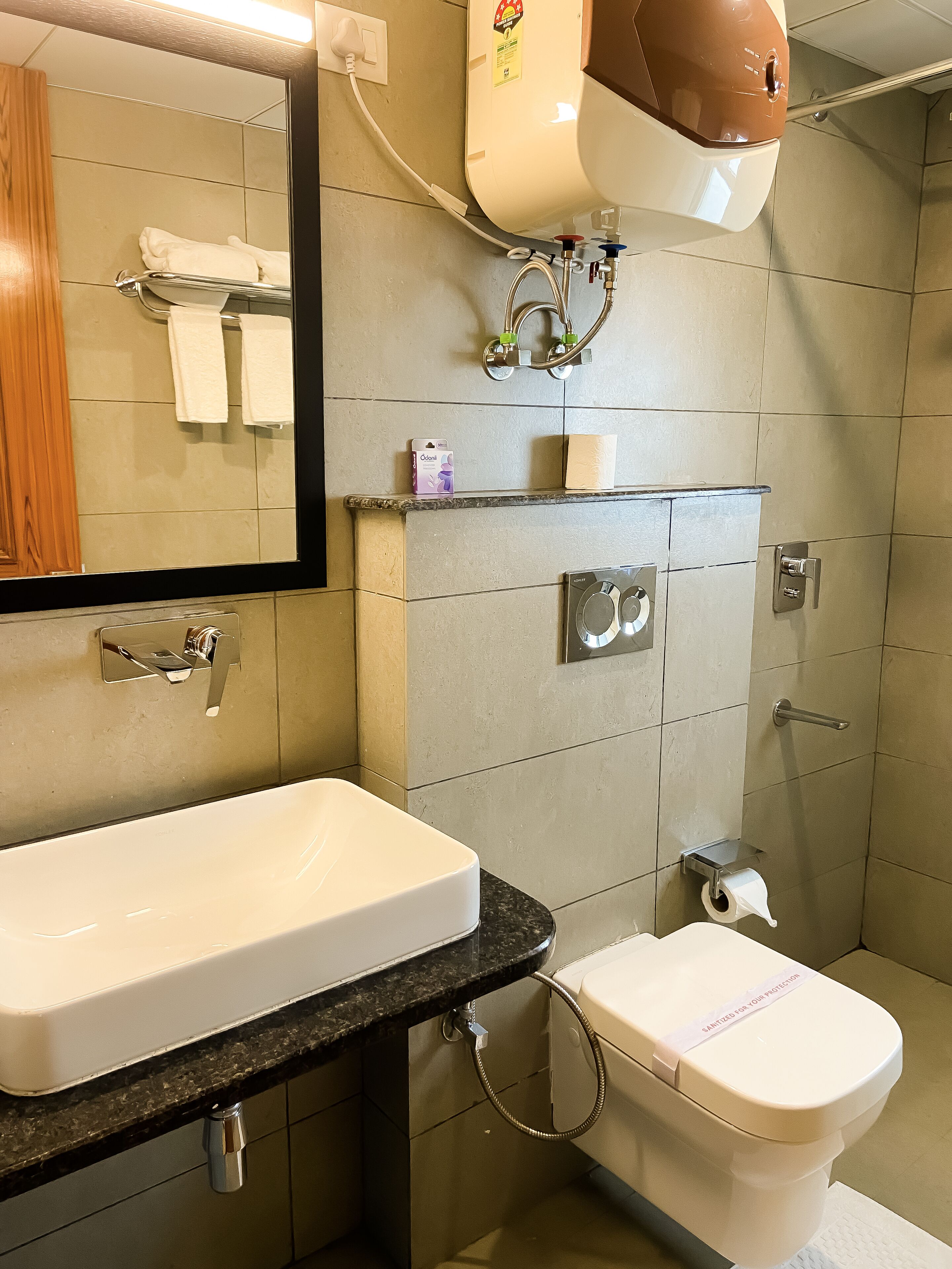 A bathroom with a white sink, a toilet, and a shower area.