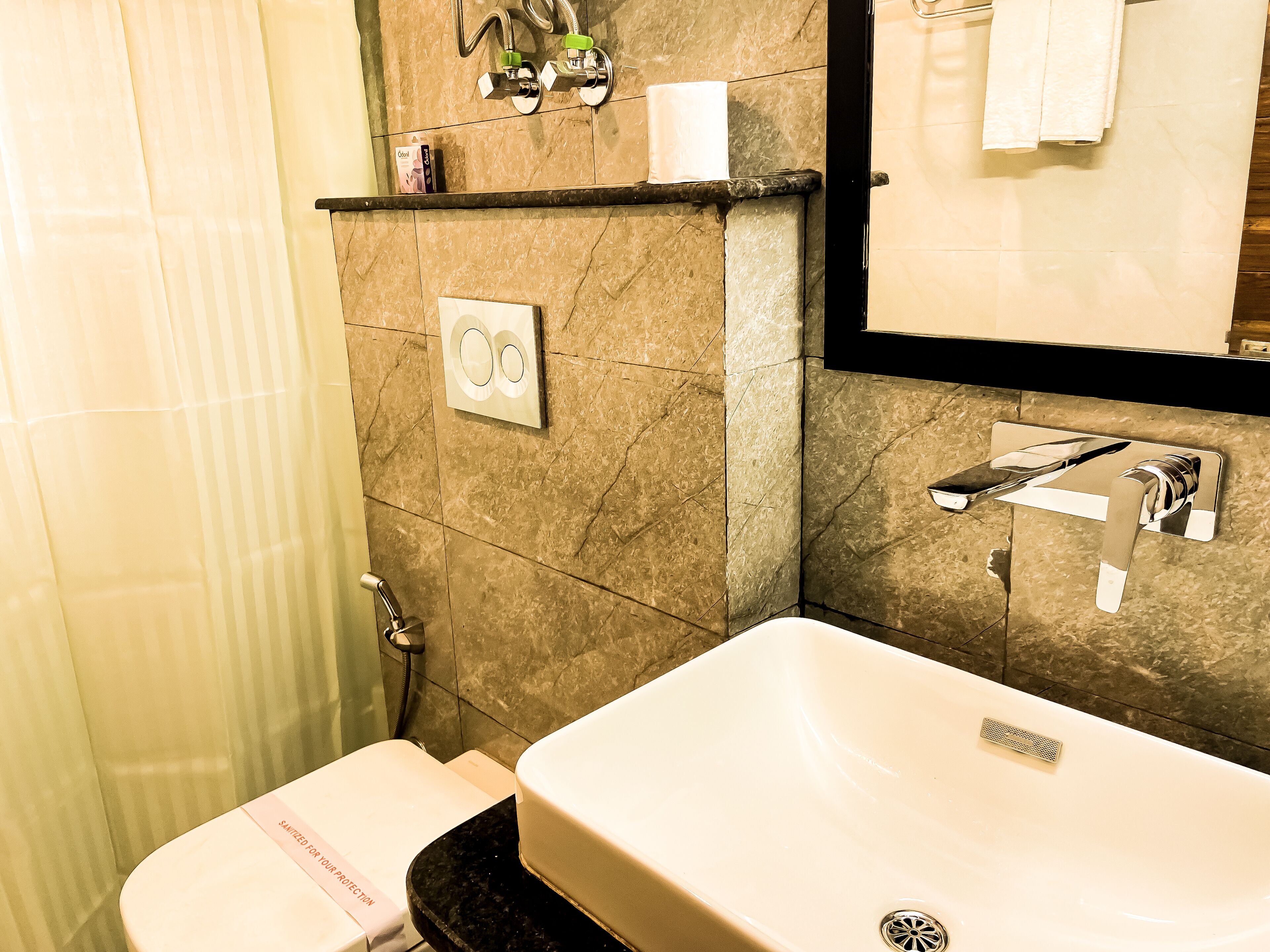 A bathroom with a white sink, a mirror, a towel rack, and a toilet.