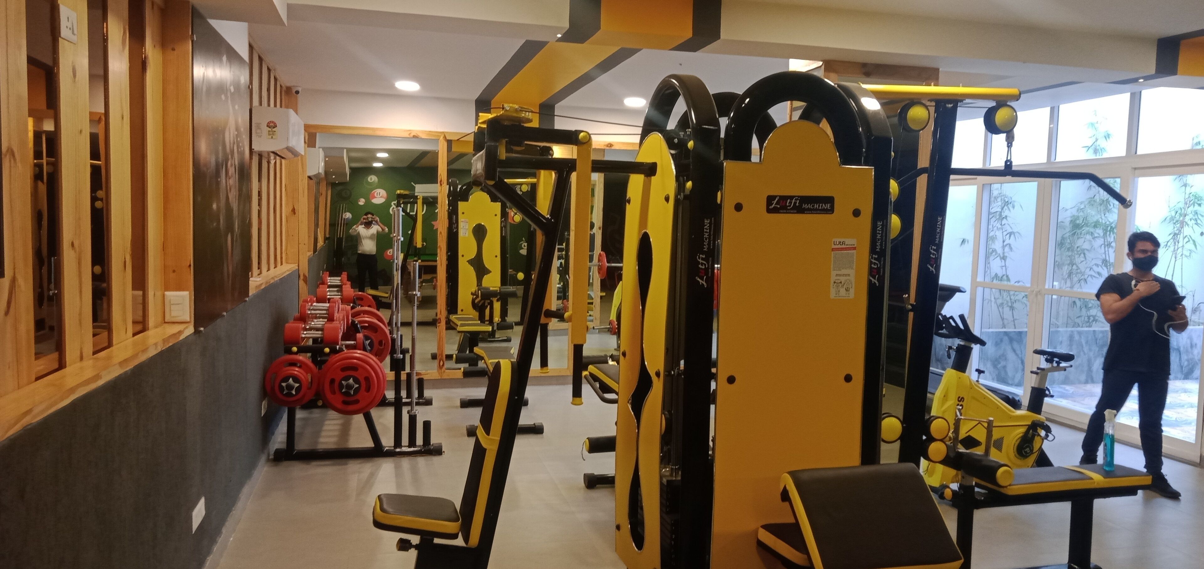 Un gimnasio con diversos equipos de ejercicio, incluyendo máquinas de pesas y aparatos de cardio.