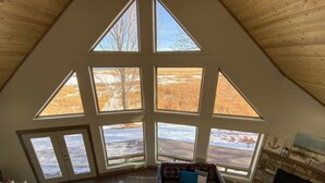 Ein geräumiges Loft mit hohen Decken, großen Fenstern, einem gemütlichen Kamin und einer komfortablen Sitzecke.