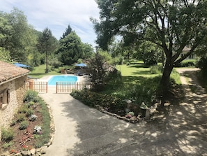 Ein Garten mit Schwimmbad, umgeben von einem Holzzaun und einer Vielfalt an Pflanzen und Blumen.
