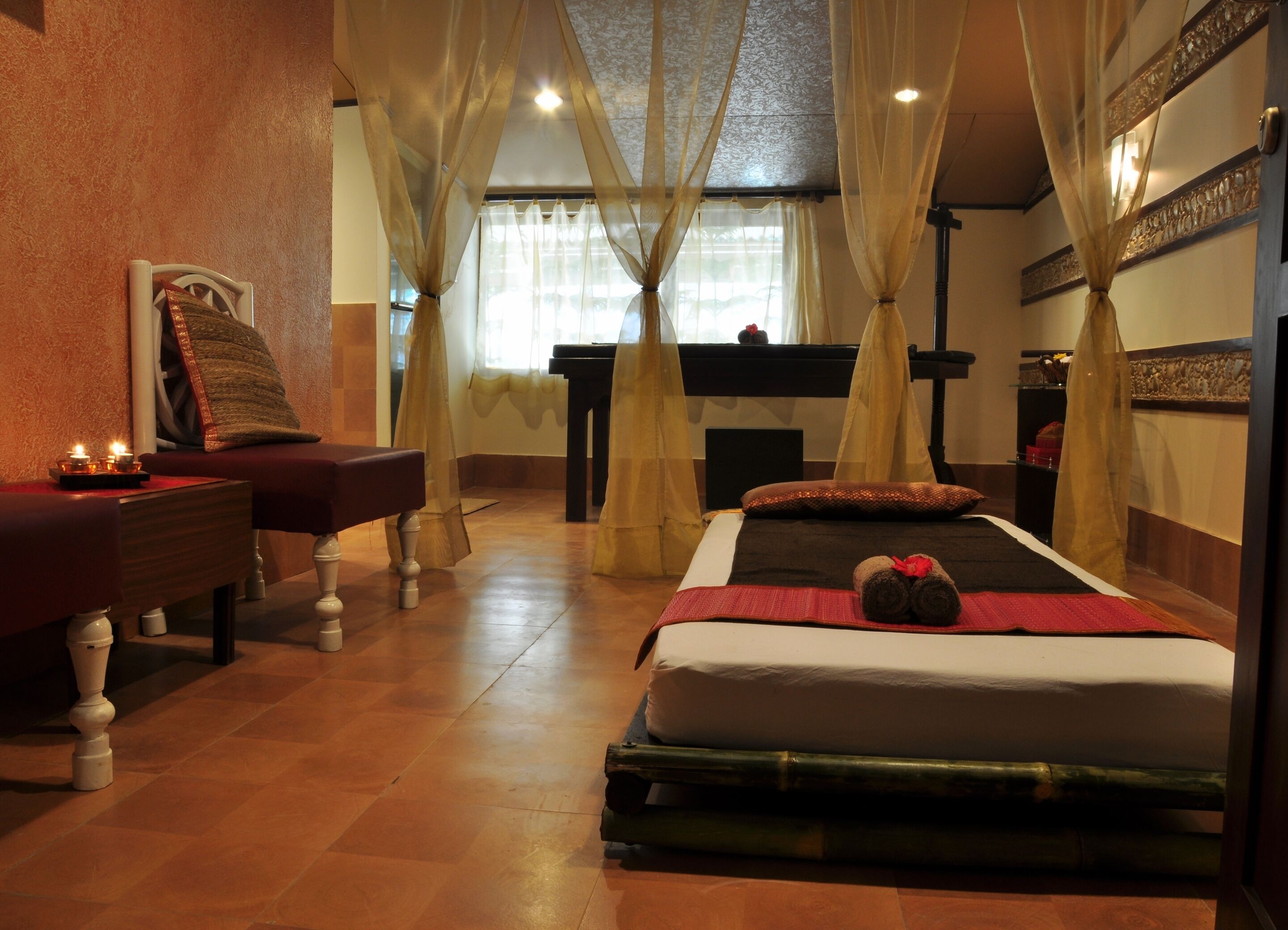 A room with a bed, a massage table, and a piano.