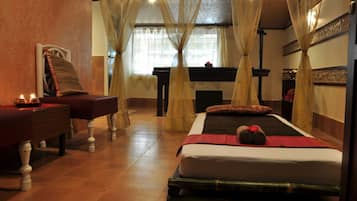 A room with a bed, a massage table, and a piano.